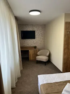 a hotel room with a television and a chair at Alen Mak in Govedartsi