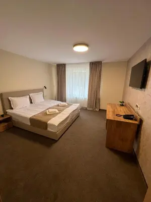 a bedroom with a large bed and a television at Alen Mak in Govedartsi