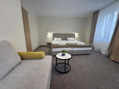 a hotel room with two beds and a couch at Alen Mak in Govedartsi
