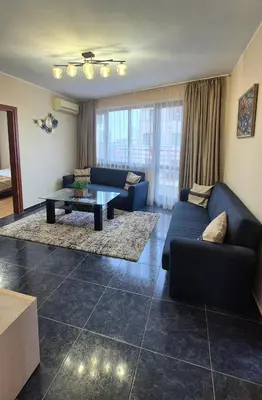 a living room with a blue couch and a table at Elit Apartment - City and Hill view in Plovdiv