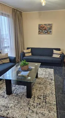 a living room with a blue couch and a coffee table at Elit Apartment - City and Hill view in Plovdiv