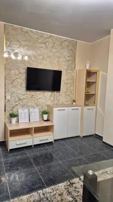 a living room with a television on a stone wall at Elit Apartment - City and Hill view in Plovdiv