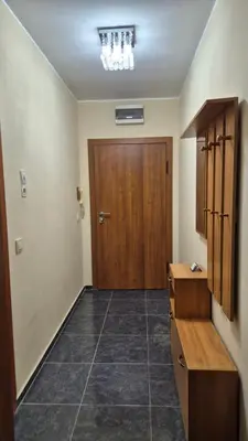 a hallway with a wooden door and a tiled floor at Elit Apartment - City and Hill view in Plovdiv