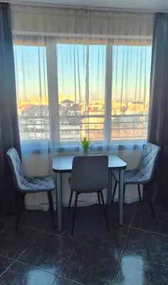 a dining room with a table and chairs and a window at Elit Apartment - City and Hill view in Plovdiv