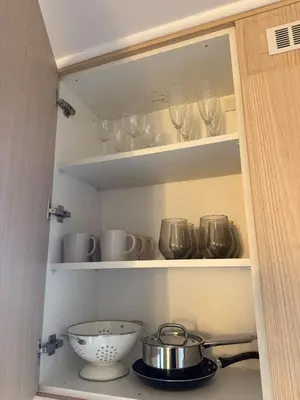 a cupboard filled with wine glasses and a bowl at Appartement moderne et chic Ski & Spa Bansko in Bansko