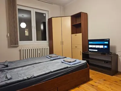 a bedroom with a bed and a television in it at Super Central 2BR FREE Parking in Sofia