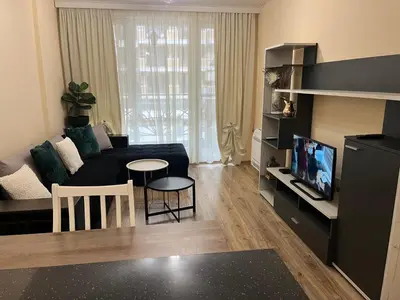 a living room with a black couch and a table at Guest House Amaya Med 2 in Plovdiv
