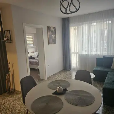 a living room with a table and chairs and a couch at Luxury Suite Old Plovdiv with parking in Plovdiv