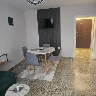 a table and chairs in a living room with a television at Luxury Suite Old Plovdiv with parking in Plovdiv