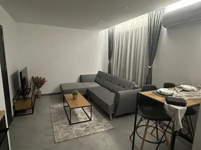 a living room with a couch and a table at Le bijou-Беломорски in Plovdiv
