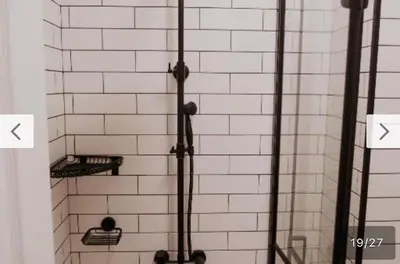 a white tiled wall with two shelves in a shower at Le bijou-Tomov Plaza in Plovdiv