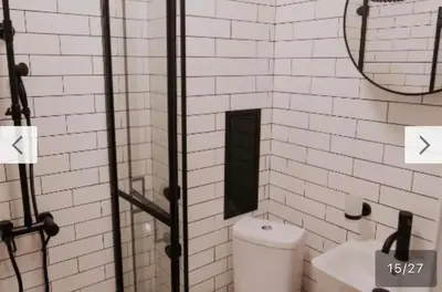 a white tiled bathroom with a toilet and a mirror at Le bijou-Tomov Plaza in Plovdiv