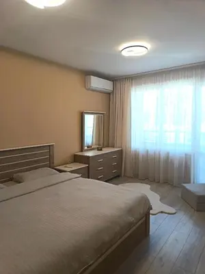 a bedroom with a bed and a dresser and a window at Boutique apartment family 5 in Plovdiv