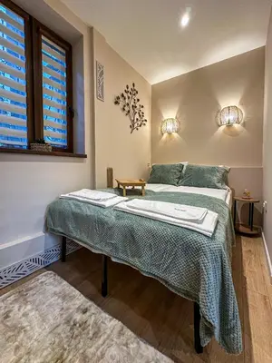 a bedroom with a bed and two windows at Heart of Sofia Apartment in Sofia