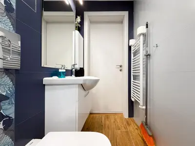 a bathroom with a white sink and a toilet at Stylish 2-Bedroom Sofia Stay in Sofia