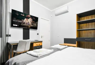 a bedroom with a bed and a flat screen tv at Stylish 2-Bedroom Sofia Stay in Sofia