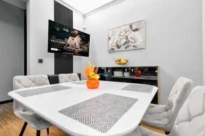 a white dining room with a white table and chairs at Stylish 2-Bedroom Sofia Stay in Sofia