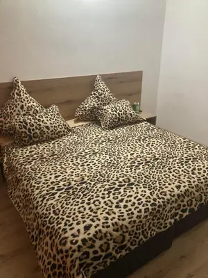 a bed with a leopard print blanket and pillows at Casa De Zambini in Plovdiv