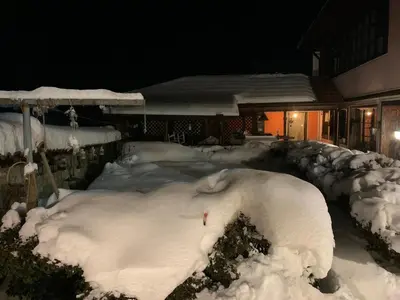 a yard covered in snow in front of a house at Карагьозовата Къща - цяла къща - 6 големи спални, 6 бани и отделна механа in Koprivshtitsa