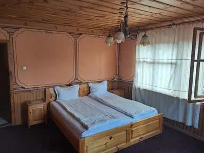 a bedroom with a bed with a wooden headboard at Карагьозовата Къща - цяла къща - 6 големи спални, 6 бани и отделна механа in Koprivshtitsa
