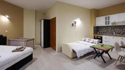 a bedroom with two beds and a table in it at Студио Young Gogh in Pamporovo