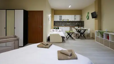 a bedroom with two beds and a kitchen and a living room at Студио Young Gogh in Pamporovo