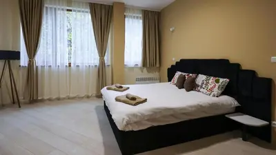 a bedroom with a black bed with towels on it at Студио Young Gogh in Pamporovo