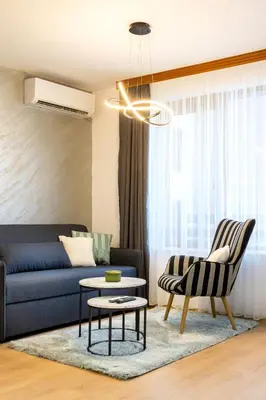 a living room with a blue couch and a chair at Evergreen 301 - Luxury ski apartment near gondola in Bansko