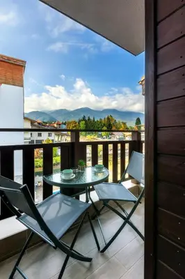 a patio with a table and chairs on a balcony at Evergreen 301 - Luxury ski apartment near gondola in Bansko