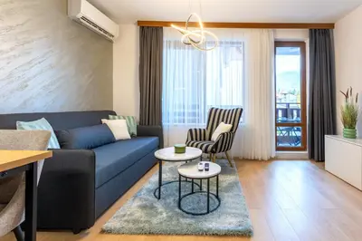 a living room with a blue couch and chairs at Evergreen 301 - Luxury ski apartment near gondola in Bansko