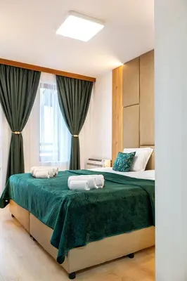a bedroom with two beds with green sheets and a window at Evergreen 301 - Luxury ski apartment near gondola in Bansko