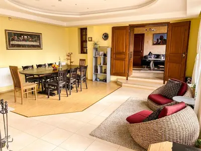 a dining room and living room with a table and chairs at Villa Madera - Spacious House with Swimming Pool, Sauna and Pool Table in Saparewo