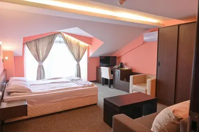a hotel room with a bed and a window at Хотел Елица in Bansko