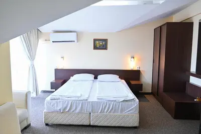 a hotel room with a bed and a window at Хотел Елица in Bansko