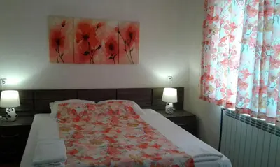 a bedroom with a bed and a painting on the wall at Къща за гости Семейство Петрови in Kalofer