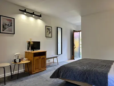 a bedroom with a bed and a tv and a table at Devonshire Lodge Chalet in Bansko