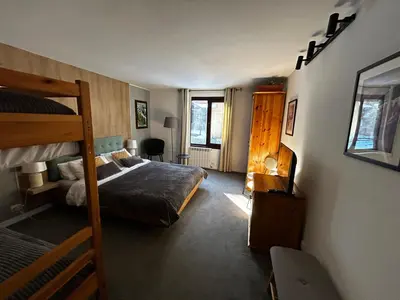 a bedroom with a bed and a bunk bed at Devonshire Lodge Chalet in Bansko