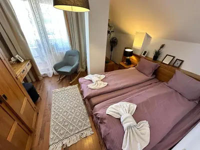 a bedroom with a purple bed and a chair at Murphys Lodge panorama apartment in Bansko