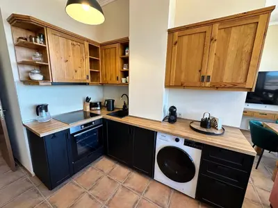 a kitchen with wooden cabinets and a washer and dryer at Murphys Lodge panorama apartment in Bansko