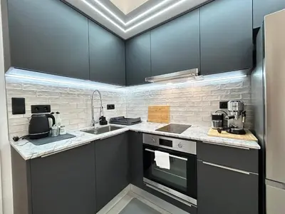 a kitchen with black cabinets and a sink at Diamond Apartment in Plovdiv