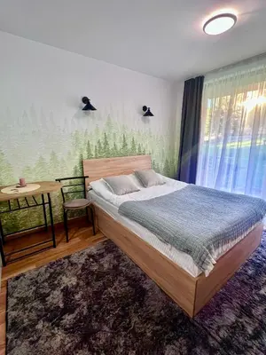 a bedroom with a bed and a table and a window at Flat F6 Bansko Rentals in Bansko