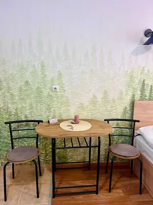 a table and two chairs in a room with a forest mural at Flat F6 Bansko Rentals in Bansko