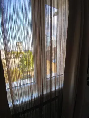 a window with curtains with a view of a city at Apartment PS in Sofia