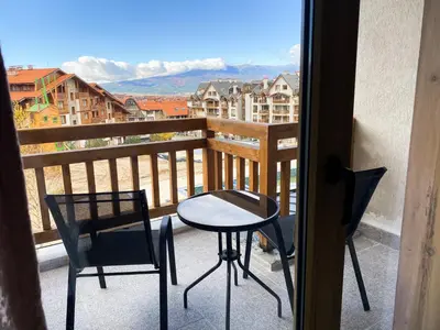 a balcony with a table and two chairs and a view at ELDORA Deluxe Private Apartment in Bansko