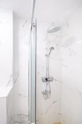 a shower in a bathroom with white marble at Comfort 1 Bedroom App in Plovdiv