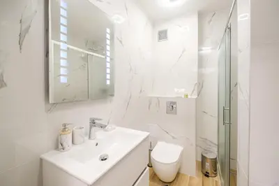 a white bathroom with a sink and a toilet at Comfort 1 Bedroom App in Plovdiv