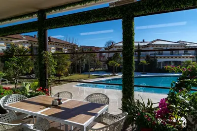 a patio with a table and chairs and a swimming pool at Hotel Paradise in Ognyanovo