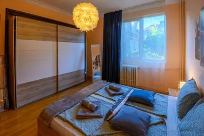a bedroom with a large bed with a large window at Cozy Central Apartment By NDK and Vitosha Blvd with Free secured parking and two terraces in Sofia