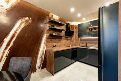 a kitchen with black cabinets and wooden walls at Beni Deluxe in Plovdiv