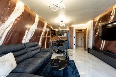 a living room with a couch and a television at Beni Deluxe in Plovdiv